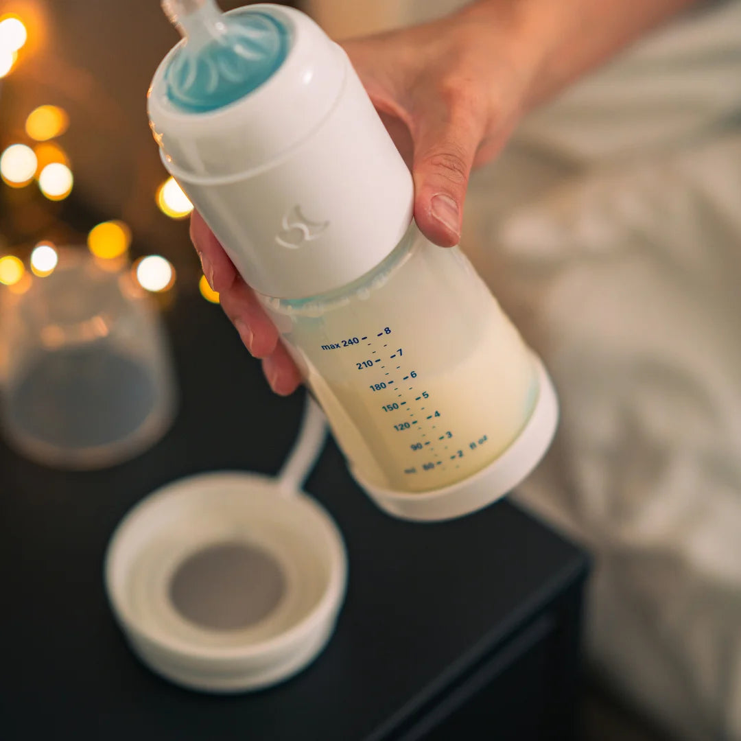 snoozi Nachtflasche Babyflasche wird geschüttelt um Milchpulver und Wasser zu vermischen