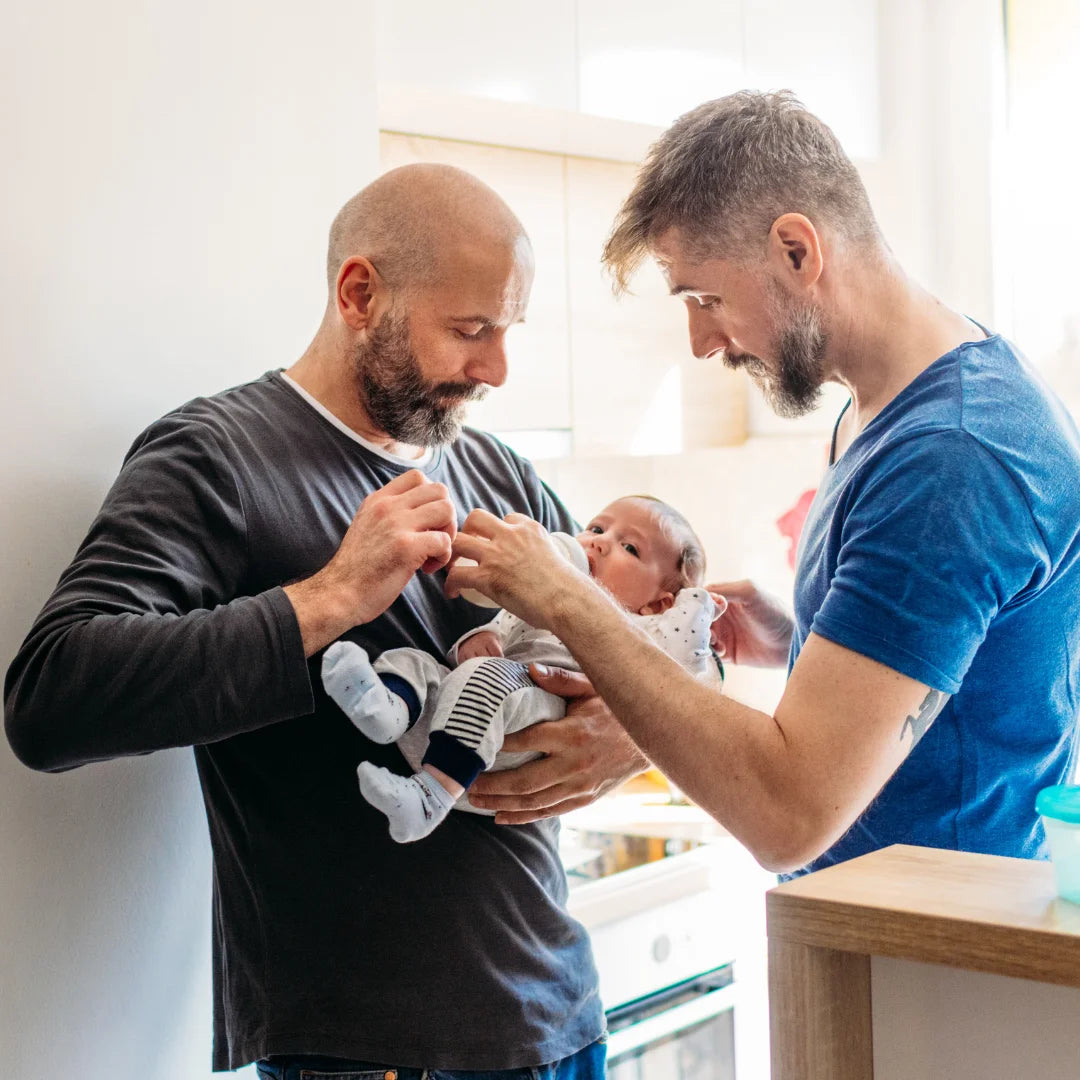 zwei Väter geben ihrem kleinen Baby die Flasche